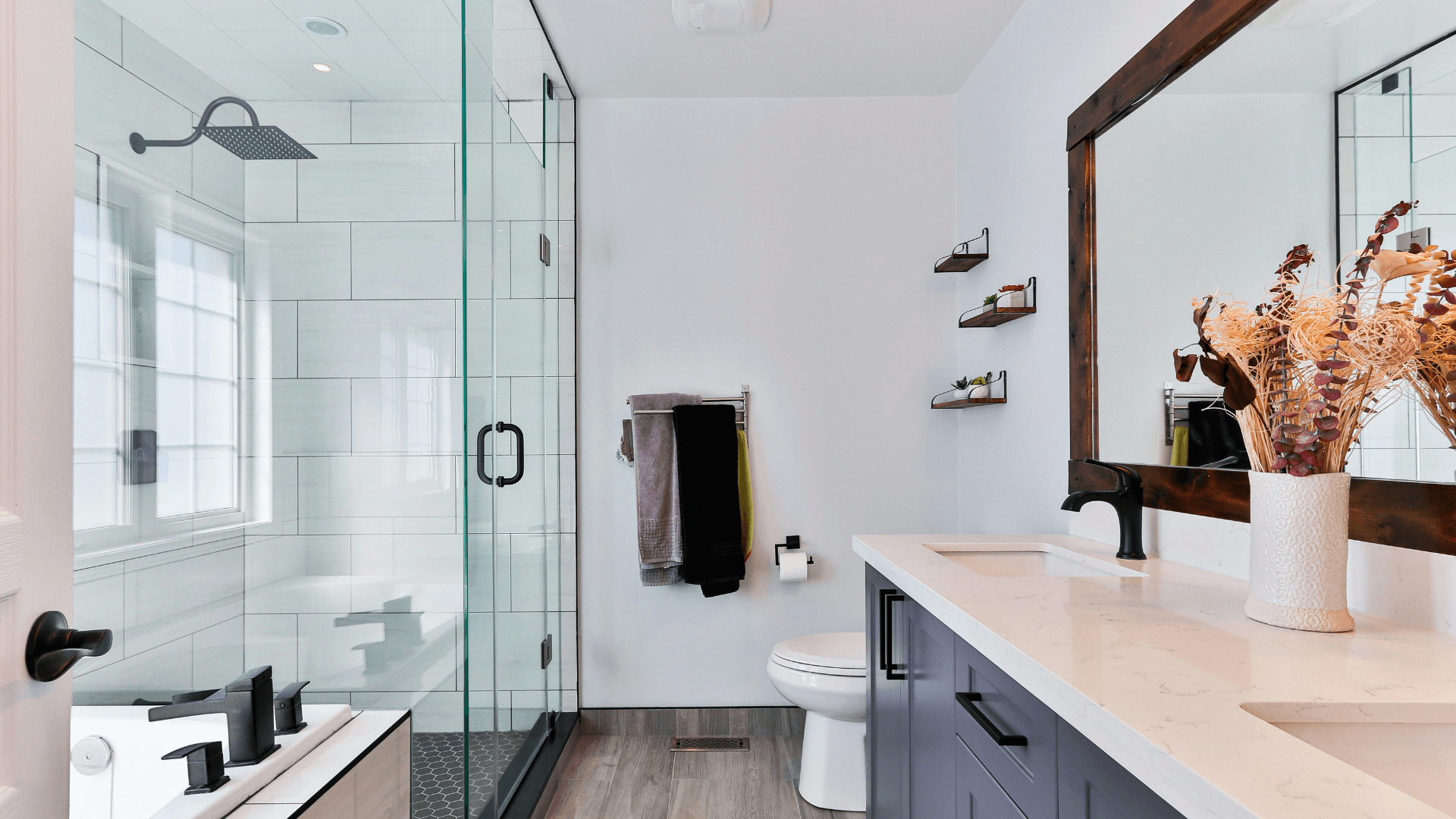 A modern bathroom with a sleek vanity, glass shower, and elegant lighting.