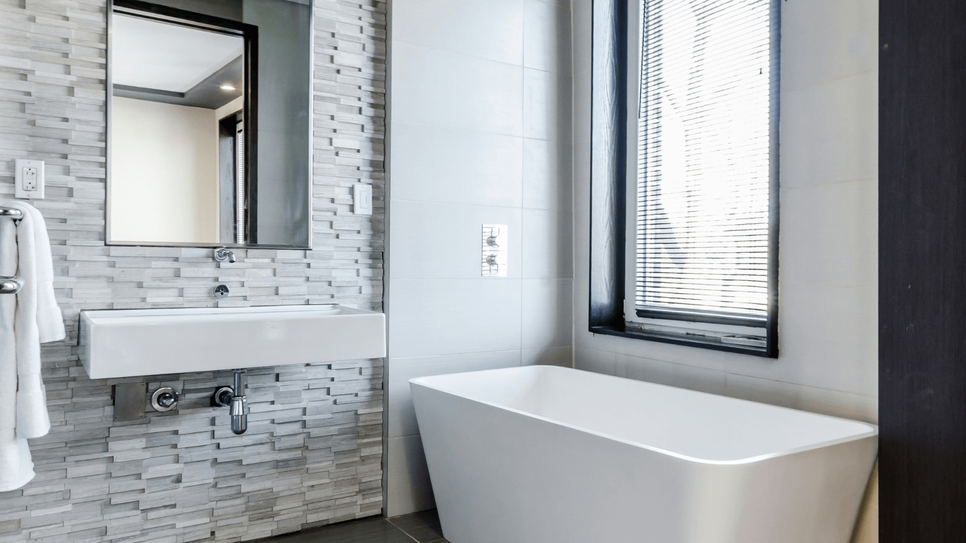 A modern bathroom with a sleek vanity, glass shower, and elegant lighting.